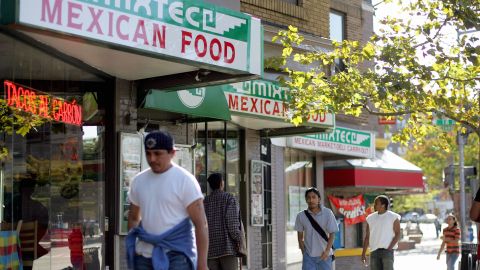 Washington, UNITED STATES: People walk past a Mexican restaurant 02 October 2006 in the Adams Morgan neighborhood of Washington, DC, where one comes in touch with the myriad sights, sounds of music and aroma of cooking from the Latino world. Latin-American residents of Washington, DC share the condemnation with residents and leaders of South and Central America over the building of a wall on the US-Mexico border. The US Congress on 29 September 2006 approved the construction of a 700-mile (1,125 kilometer) wall along the border, over which tens of thousands of mainly Latin American illegal immigrants pass each year. AFP PHOTO / TIM SLOAN (Photo credit should read TIM SLOAN/AFP via Getty Images)