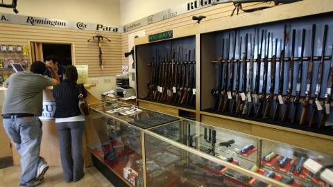 Glendale, UNITED STATES: A couple chooses a gun at the Gun Gallery in Glendale, California, 18 April 2007. The massacre at Virginia Tech has ignited fresh talk in the Democratic-led US Congress about tightening US gun laws but it is doubtful enough lawmakers will tackle the politically charged issue. With so many citizens in love with their guns and defensive of their right under the Constitution to keep and bear arms, politicians are reluctant to take on gun owners or the powerful gun lobby. AFP PHOTO/GABRIEL BOUYS (Photo credit should read GABRIEL BOUYS/AFP via Getty Images)