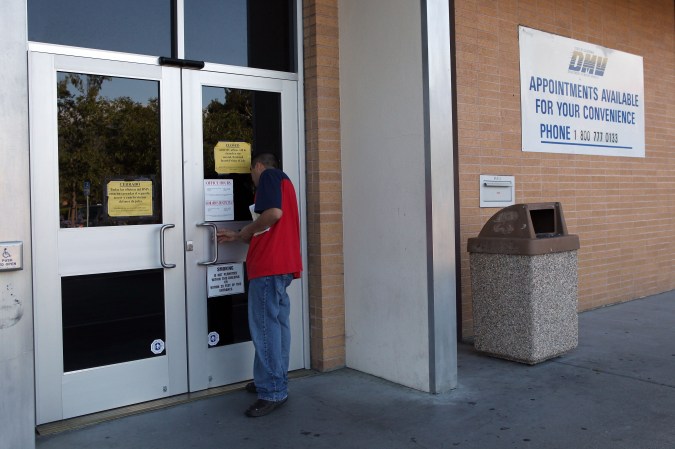 CORTE MADERA, CA - JULY 10: A California Department of Motor Vehicles customer peers into the door of a closed DMV branch July 10, 2009 in Corte Madera, California. As California struggles with a $26-billion budget imbalance, Gov. Arnold Schwarzenegger declared a state of emergency earlier this month and has ordered three work furlough days per month leaving most state offices closed today. (Photo by Justin Sullivan/Getty Images)