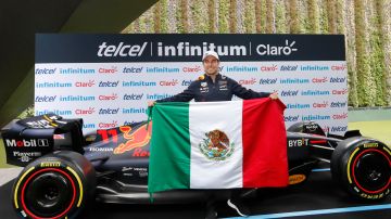Sergio Checo Pérez posando con una bandera de México.