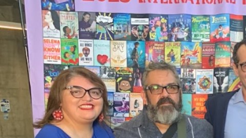 El profesor Armando Vázquez-Ramos aparece al centro sosteniendo el reconocimiento.