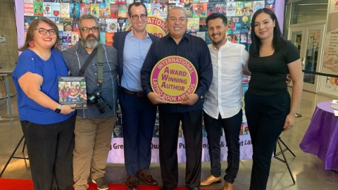El profesor Armando Vázquez-Ramos aparece al centro sosteniendo el reconocimiento.