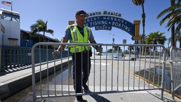A police officer closes access to the Santa Monica pier in Santa Monica, California, March 23, 2020 as people are encouraged to stay at home to halt the spread of the novel coronavirus, COVID-19. (Photo by Robyn Beck / AFP) (Photo by ROBYN BECK/AFP via Getty Images)
