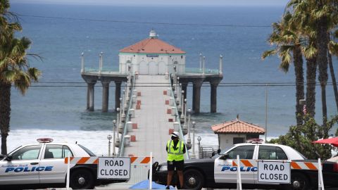 Police cars block the entrance to the pier in Manhattan Beach, California, where beaches are closed due to a spike in COVID-19 in Los Angeles County, on July 4, 2020, the US Independence Day holiday. Beaches and indoor restaurant seating in Los Angeles County are closed to help fight the spread of the coronavirus pandemic. (Photo by Robyn Beck / AFP) (Photo by ROBYN BECK/AFP via Getty Images)