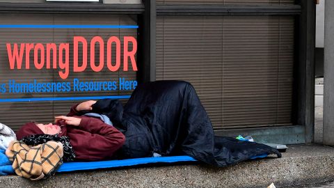 A homeless woman sleeps in front of a homelessness resource center in Los Angeles, California on February 1, 2021. - The federal judge overseeing attempts to resolve the homeless situation has called for an urgent meeting to discuss worsening conditions and the poor official response. Combined now with the coronaviruspandemic and worsening mental health and substance abuse issues, US District Judge David Carter who toured Skid Row last week likened the situation to "a significant natural disaster in Southern California with no end in sight." (Photo by Frederic J. BROWN / AFP) (Photo by FREDERIC J. BROWN/AFP via Getty Images)