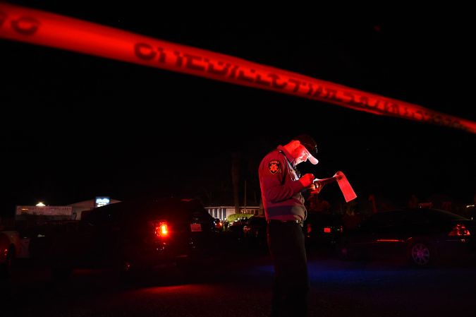 TOPSHOT - A San Mateo County sheriff deputy stands at the scene of a shooting on highway 92 in Half Moon Bay, California on January 23, 2023. - An Asian farm worker was in custody January 23, 2023 after seven of his colleagues were killed in front of children at sites in California, days after a mass shooter killed 11 people at a Lunar New Year celebration near Los Angeles. The latest bloodshed to hit Asian Americans in California occurred at two farms around Half Moon Bay, a coastal community near San Francisco. (Photo by Susana BATES / AFP) (Photo by SUSANA BATES/AFP via Getty Images)