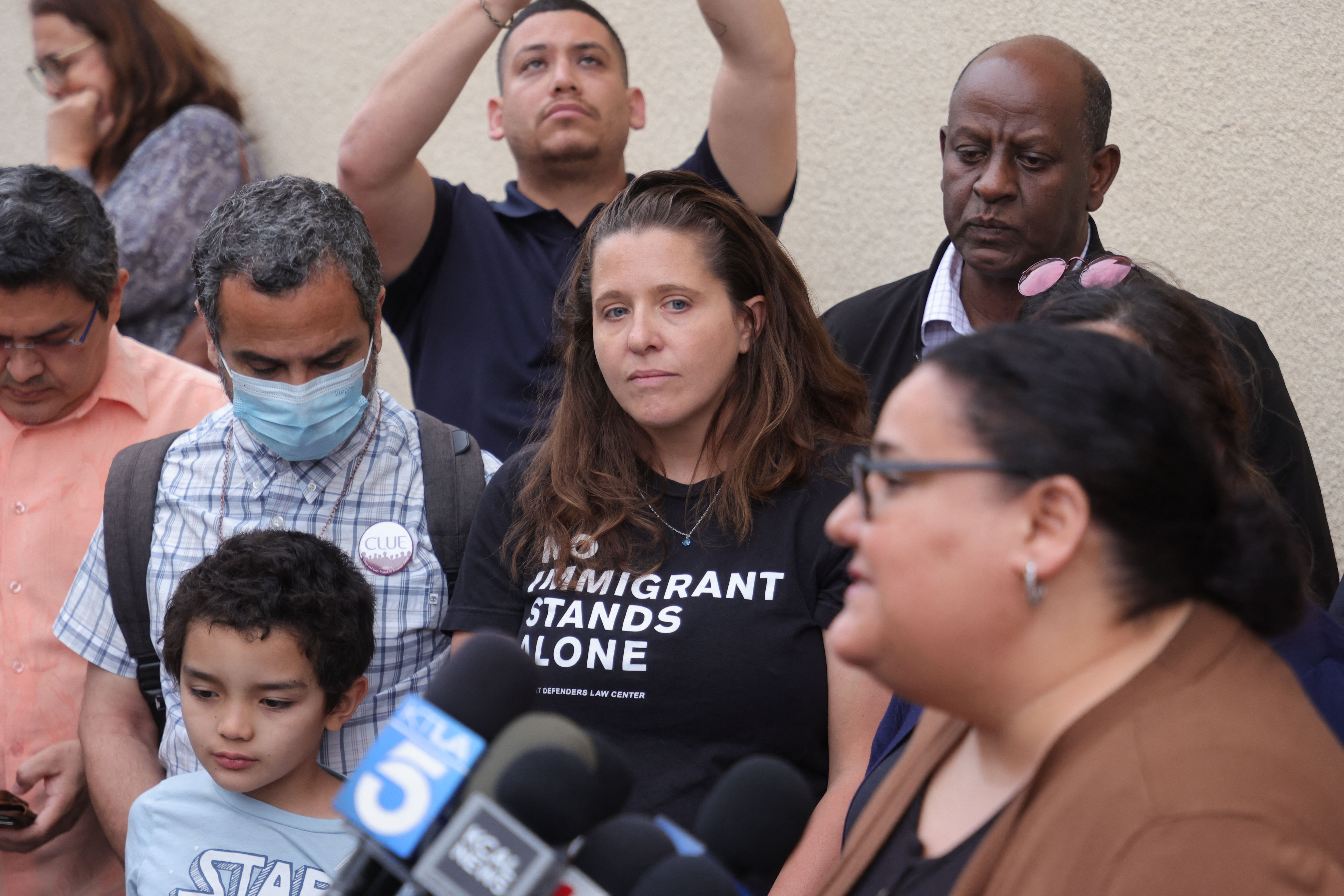 Lindsay Toczylowski (C), executive director of Immigrant Defenders Law Center, listens to a speaker outside St. Anthony Croatian Catholic Church where migrants have been transported in Los Angeles, June 14, 2023. A busload of 42 migrants including 8 children, had arrived at Union Station in Los Angeles from Texas as claimed by Governor Greg Abbott Wednesday, June 14, 2023. (Photo by DAVID SWANSON / AFP) (Photo by DAVID SWANSON/AFP via Getty Images)