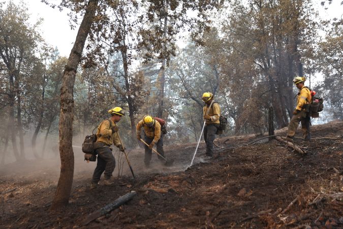 JERSEYDALE, CALIFORNIA - JULY 25: Cal Fire firefighters mop up hot spots after the Oak Fire moved through the area on July 25, 2022 near Jerseydale, California. The Oak Fire burning outside of Yosemite National Park has forced evacuations, charred 16,791acres and has destroyed several homes since starting on Friday afternoon. The fire is 10 percent contained. (Photo by Justin Sullivan/Getty Images)