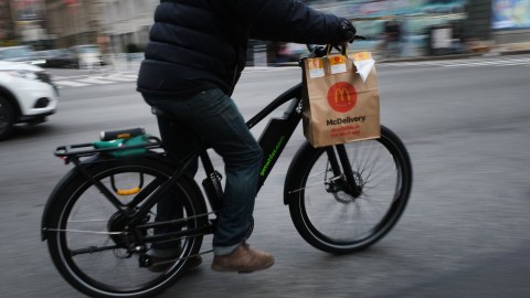 NEW YORK, NEW YORK - NOVEMBER 15: A delivery person rides an electric bicycle through the streets of Manhattan on November 15, 2022 in New York City. Electric bicycles, which have surged in popularity with both delivery workers and commuters, run on lithium-ion batteries which can be combustible when charging, especially cheaper models. Some New York City landlords are banning electric bicycles from their buildings following a series of fires, one in Manhattan this month which sent 43 people to the hospital after a faulty bike battery left charging by a tenant caught fire. (Photo by Spencer Platt/Getty Images)