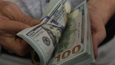 A teller flicks through a bundle of US dollar bills at an exchange office in Ankara on July 20, 2023. Turkey's central bank hiked its main interest rate for the second month in a row, but analysts said the unwinding of President Recep Tayyip Erdogan's unconventional policy was too timid to tame inflation. After years of cuts that aimed to boost growth but fuelled inflation and caused the lira to tumble, the bank doubled its rate last month from 8.5 percent to 15 percent. The latest hike was smaller, at 2.5 percentage points, taking the rate to 17.5 percent. (Photo by Adem ALTAN / AFP) (Photo by ADEM ALTAN/AFP via Getty Images)