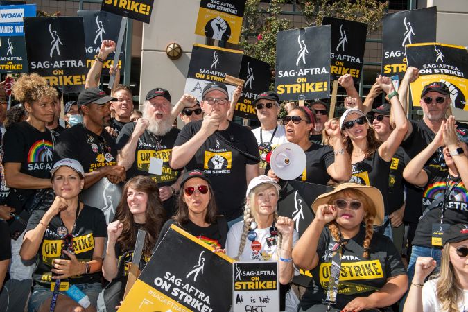 Duncan Crabtree-Ireland (C), executive director and chief negotiator for SAG AFTRA, and the members of the negotiating committee address the SAG AFTRA members at the picket line outside of Warner Brothers in Burbank, California, on October 3, 2023. The bulk of film and television production across the US has been at a standstill since scribes walked out in early May, being joined by actors in July, all seeking a better deal and assurances their jobs won't be lost to artificial intelligence. (Photo by VALERIE MACON / AFP) (Photo by VALERIE MACON/AFP via Getty Images)