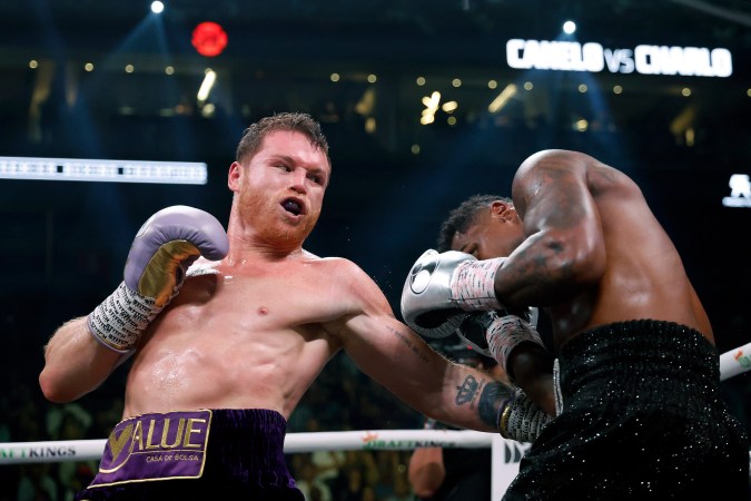 LAS VEGAS, NEVADA - SEPTEMBER 30: Saul "Canelo" Alvarez of Mexico (purple/gold trunks) trades punches with Jermell Charlo (black trunks) during their super middleweight title fight at T-Mobile Arena on September 30, 2023 in Las Vegas, Nevada. (Photo by Sarah Stier/Getty Images)