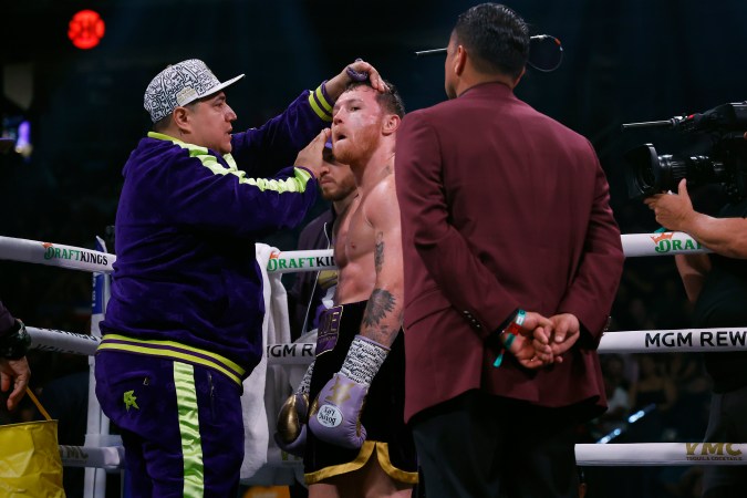 LAS VEGAS, NEVADA - SEPTEMBER 30: Saul "Canelo" Alvarez of Mexico (purple/gold trunks) is attended to between rounds of a super middleweight title fight against Jermell Charlo ( black trunks) at T-Mobile Arena on September 30, 2023 in Las Vegas, Nevada. (Photo by Sarah Stier/Getty Images)