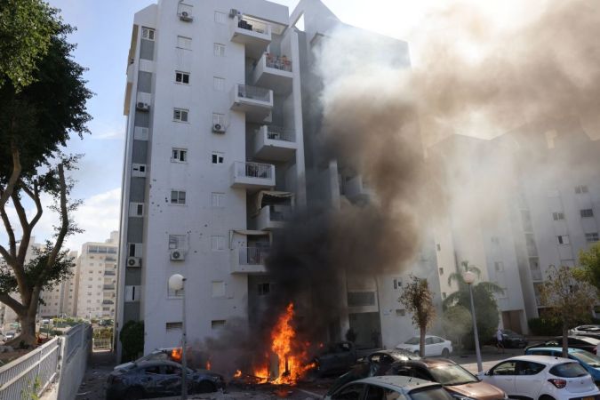 Automóviles estacionados frente a un edificio residencial se incendian durante un ataque con cohetes desde la Franja de Gaza hacia la ciudad sureña de Ashkelon, en Israel.