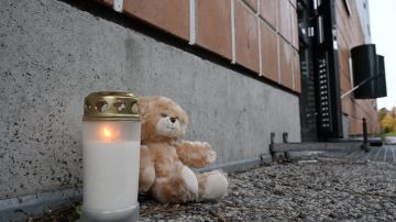 A candle and a teddy bear are seen in front of the accident scene at a residential building in Vantaa, Finland, on October 8, 2023. A fire broke out in a flat on the bottom floor of a residental block in Vantaa early on Sunday, October 8, 2023, killing five people. Four of the dead were children. (Photo by Jussi Nukari / Lehtikuva / AFP) / Finland OUT (Photo by JUSSI NUKARI/Lehtikuva/AFP via Getty Images)