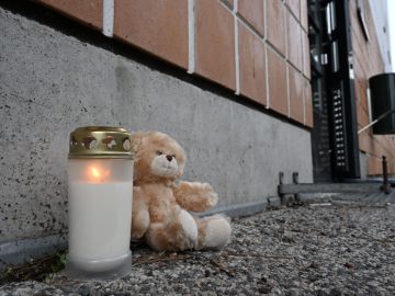 A candle and a teddy bear are seen in front of the accident scene at a residential building in Vantaa, Finland, on October 8, 2023. A fire broke out in a flat on the bottom floor of a residental block in Vantaa early on Sunday, October 8, 2023, killing five people. Four of the dead were children. (Photo by Jussi Nukari / Lehtikuva / AFP) / Finland OUT (Photo by JUSSI NUKARI/Lehtikuva/AFP via Getty Images)