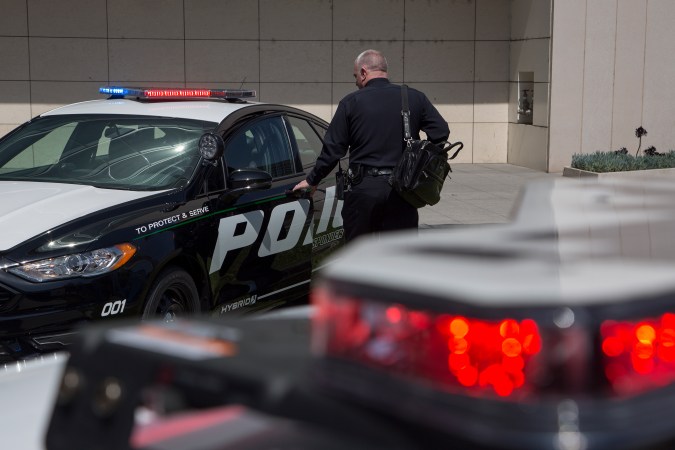 LOS ANGELES, CA - APRIL 10: An LAPD officer looks at a car at the unveiling of two new Ford Fusion hybrid pursuit-rated Police Responder cars at Los Angeles Police Department headquarters on April 10, 2017 in Los Angeles, California. The LAPD is committed to purchasing at least 300 hybrid and hybrid-electric plug-in vehicles by 2020. (Photo by David McNew/Getty Images)