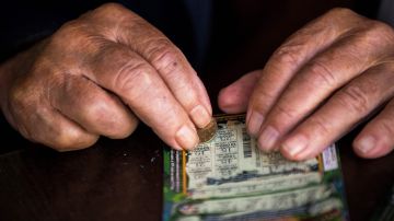 A picture shows Stoyan Stoimenov, 96, scrbing a scratchcard at a local coffee shop in the village of Tsurkva, near the capitol of Sofia, on May 28, 2018. - Stoimenov is just one of thousands of Bulgarians who have been gripped by a craze for scratchcards in recent years in the EU's poorest member state, with some now raising the alarm over the dangers of widespread addiction. According to an estimate by Bulgaria's Capital financial weekly, 100 million scratchcards were sold in 2017 in a country of less than seven million people. (Photo by Nikolay DOYCHINOV / AFP) (Photo credit should read NIKOLAY DOYCHINOV/AFP via Getty Images)
