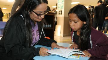 Veearae Pérez lee un libro a su abuelita, Esperanza Mejía, en la nueva biblioteca en la Cárcel Central de Hombres del condado de Los Ángeles.