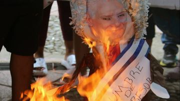 Migrantes en México queman piñatas de presidentes en protesta contra la cumbre migratoria