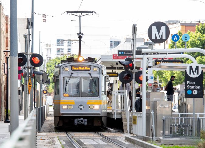 A woman wearing a face mask drives a Metro line train in the downtown area on March 8, 2021 in Los Angeles, California. (Photo by VALERIE MACON / AFP) (Photo by VALERIE MACON/AFP via Getty Images)