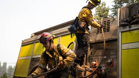 WESTWOOD, CA - AUGUST 09: Firefighters from Huntington Beach pull up a hose after extinguishing a small blaze on August 9, 2021 near Westwood, California. The Dixie Fire, which has incinerated nearly 500,000 acres, is the second-largest recorded wildfire in state history and remains only 21 percent contained. (Photo by Maranie R. Staab/Getty Images)