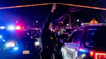 A Sacramento County Sheriff's Department officer holds up police tape to allow a vehicle to enter a crime scene outside a church where a man shot dead four people, including three of his children, before turning the gun on himself, February 28, 2022 in Sacramento, California. - A father shot dead three of his own children on February 28 before turning the gun on himself in a US church, police said. A fifth person also died in the shooting in Sacramento, California, though it was not clear if that person was related to what police said was a domestic incident. (Photo by Andri Tambunan / AFP) (Photo by ANDRI TAMBUNAN/AFP via Getty Images)