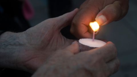 People light a candle during a memorial at Stephansplatz for Lisa-Maria Kellermayr, the deceased Austrian doctor who closed her practice after she reported receiving death threats from opponents of COVID-19 restrictions and vaccines in Vienna, Austria on August 1, 2022. - Dr Lisa-Maria Kellermayr took her own life because of the death threats and hostilities in the corona virus pandemic. (Photo by Alex HALADA / AFP) (Photo by ALEX HALADA/AFP via Getty Images)