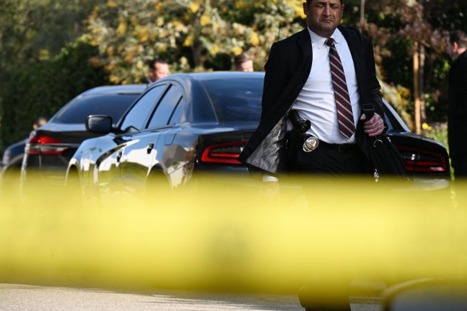 A detective walks at the scene of an investigation after an early morning shooting that left three people dead and four wounded in the Beverly Crest neighborhood of Los Angeles, just north of Beverly Hills, on January 28, 2023. - Three people were shot dead January 28 and four others injured at a luxury home near Beverly Hills, at what US police described as a gathering at a short-term rental property. (Photo by Robyn BECK / AFP) (Photo by ROBYN BECK/ AFP/AFP via Getty Images)