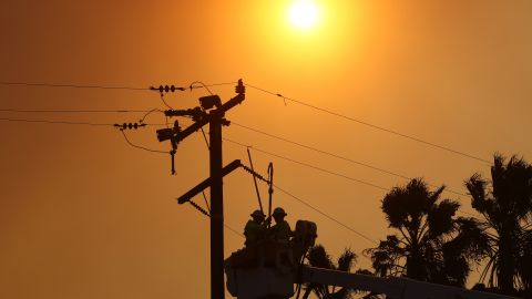 SILVERADO CANYON, CALIFORNIA - DECEMBER 03: Workers repair power lines damaged during the Bond Fire in the Silverado Canyon area of Orange County on December 3, 2020 near Irvine, California. The 4,000-acre wildfire broke out along with a number of other fires in Southern California amid gusty Santa Ana winds in the region. (Photo by Mario Tama/Getty Images)