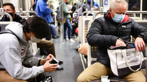 LOS ANGELES, CALIFORNIA - DECEMBER 15: People wear face coverings while riding a Los Angeles Metro Rail train on December 15, 2021 in Los Angeles, California. California residents, regardless of COVID-19 vaccination status, are required to wear face masks in all indoor public settings beginning today in response to rising coronavirus case numbers and the omicron threat. The statewide mandate will be in effect through January 15, 2022. (Photo by Mario Tama/Getty Images)