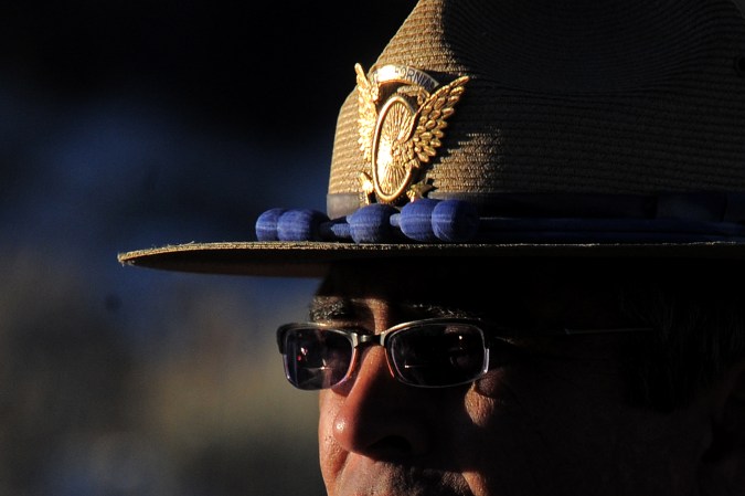 A California Highway Patrol officer guards a roadblock on Highway 38 near Big Bear Lake, California, on February 13, 2013 during a standoff with the former Los Angeles police officer Christopher Dorner. Authorities on Wednesday examined human remains found in a burned out mountain cabin to determine whether they belong to Dorner, a fugitive ex-cop wanted in at least four murders. Police discovered the remains in the cabin's charred ruins after a chase ended in a shootout with police and fire near Big Bear in the snow covered mountains east of Los Angeles where Dorner was thought to have taken refuge. AFP PHOTOS /AFP PHOTO/JOE KLAMAR (Photo credit should read JOE KLAMAR/AFP via Getty Images)