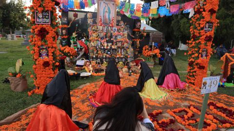 A display of family photos at a gravesite is honored as revellers celebrate Dia De Los Muertos (Day of the Dead) at Hollywood Forever Cemetery in Los Angeles, California, on October 28, 2023. Every year on the last Saturday before November 2nd, Hollywood Forever Cemetery welcomes members of the community to celebrate Dia de Los Muertos, which reunites and honors beloved ancestors, family, and friends. (Photo by DAVID SWANSON / AFP) (Photo by DAVID SWANSON/AFP via Getty Images)