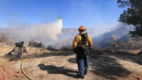 A Riverside fire captain watches a water drop as the Highland Fire burns in Aguana, California, on October 31, 2023. Thousands of people were being told to flee a wildfire spreading in southern California on October 31, as strong winds fanned the flames. Around 5,700 people were urged to leave areas threatened by the blaze, which erupted on October 30 around lunchtime and had engulfed 2,200 acres (900 hectares) by the following morning. (Photo by DAVID SWANSON / AFP) (Photo by DAVID SWANSON/AFP via Getty Images)