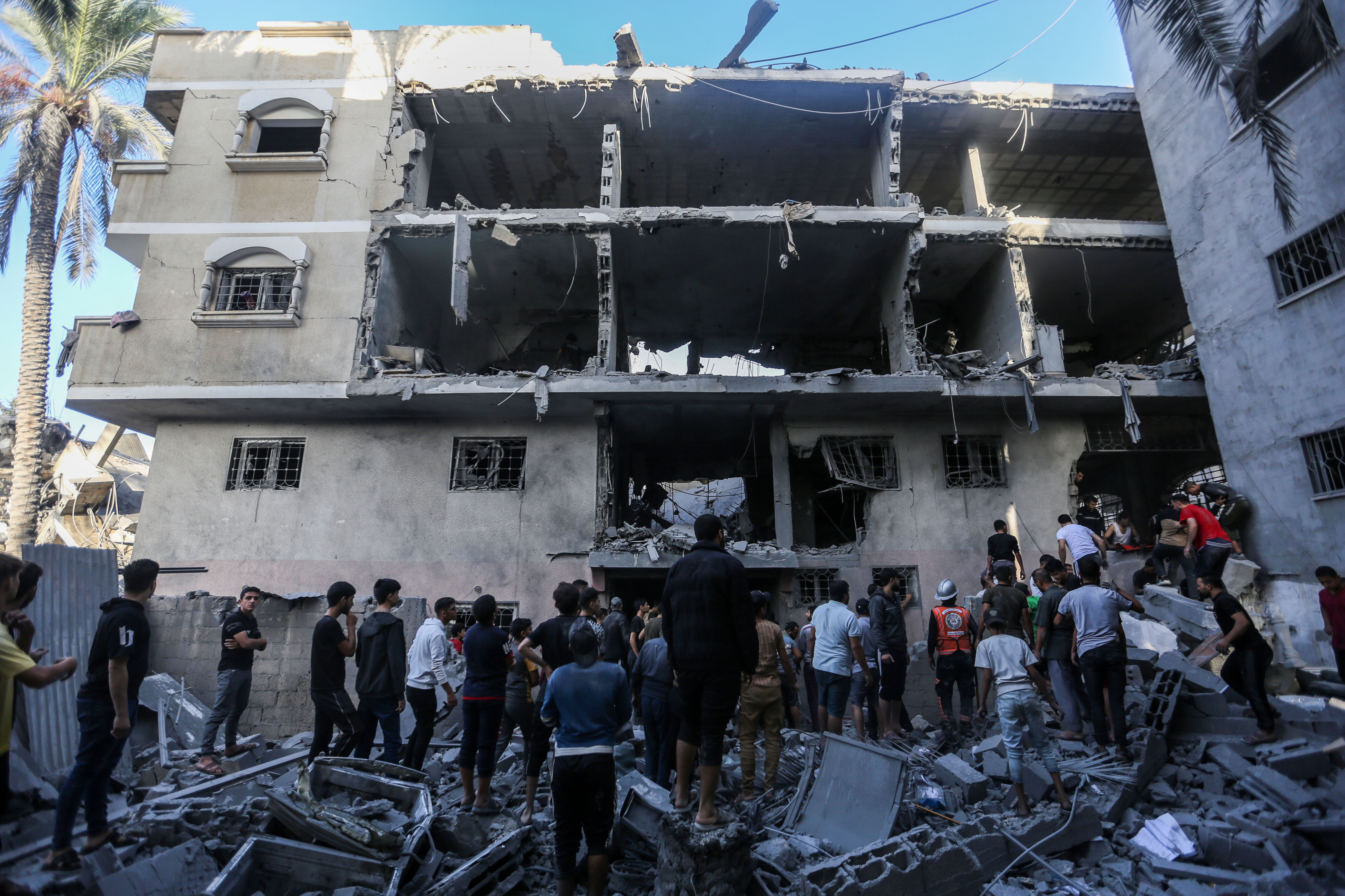 La gente busca en los edificios destruidos durante los ataques aéreos israelíes en el sur de la Franja de Gaza el 7 de noviembre de 2023 en Khan Yunis, Gaza.