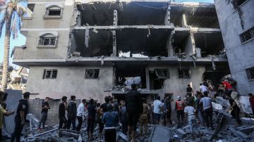 La gente busca en los edificios destruidos durante los ataques aéreos israelíes en el sur de la Franja de Gaza el 7 de noviembre de 2023 en Khan Yunis, Gaza.