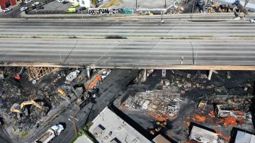 LOS ANGELES, CALIFORNIA - NOVEMBER 13: An aerial view of cleanup crews working beneath the closed I-10 freeway following a large pallet fire, which occurred Saturday at a storage yard, on November 13, 2023 in Los Angeles, California. Engineers have been assessing the extent of the damage and it remains unknown how long the freeway, which is a major commuter artery through the downtown area, will remain closed and will complicate traffic for the city. California Gov. Gavin Newsom said that over 300,000 vehicles drive through the freeway corridor each day and drivers are being urged to use public transit. (Photo by Mario Tama/Getty Images)
