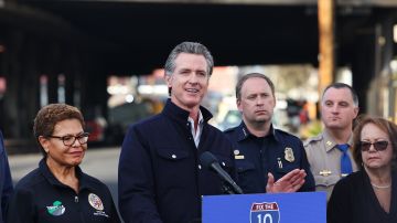 LOS ANGELES, CALIFORNIA - NOVEMBER 13: California Governor Gavin Newsom (C) speaks as Los Angeles Mayor Karen Bass (L) listens at a press conference near the closed I-10 elevated freeway following a large pallet fire, which occurred Saturday at a storage yard beneath the freeway, on November 13, 2023 in Los Angeles, California. Engineers have been assessing the extent of the damage and it remains unknown how long the freeway, which is a major commuter artery through the downtown area, will remain closed and complicate traffic for the city. Newsom said the fire was caused by arson and that over 300,000 vehicles drive through the freeway corridor each day with drivers being urged to use public transit. (Photo by Mario Tama/Getty Images)