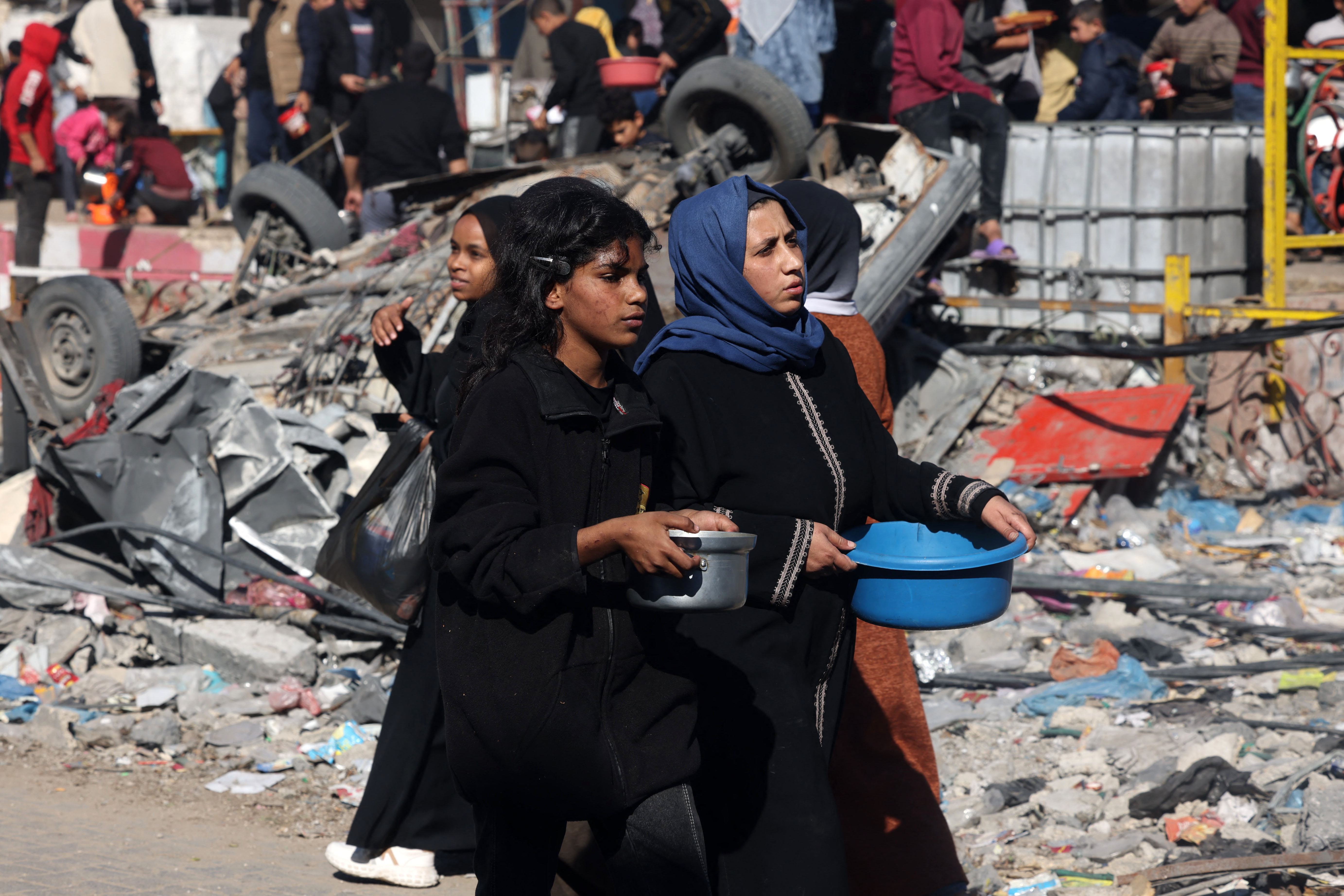 Mujeres palestinas transportan alimentos donados por un grupo benéfico en Rafah, en el sur de la Franja de Gaza.