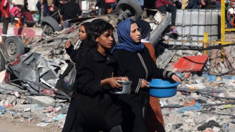 Mujeres palestinas transportan alimentos donados por un grupo benéfico en Rafah, en el sur de la Franja de Gaza.