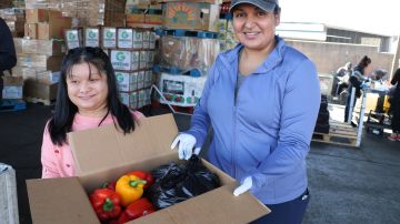 Stephanie Sandoval (d) es tutora de jóvenes con necesidades especiales que son voluntarios en el empaquetamiento de alimentos..
