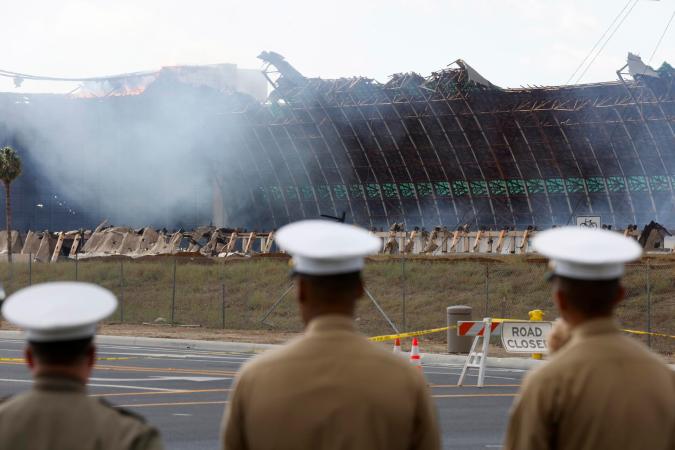 Tustin (United States), 07/11/2023.- Members of the US Navy watch a historic World War II-era wooden hangar as it burns in Tustin, California, USA, 07 November 2023. The structure caught fire on 07 November morning and the Orange County Fire Authority stated that the only way to fight the fire was to let the structure to collapse. The hanger was one of two built in 1942 for the US Navy, and were among the the largest wooden structures ever built. EFE/EPA/CAROLINE BREHMAN