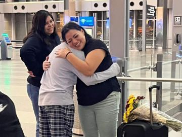 Vanessa abrazando a su hijo y reuniéndose con su familia en un aeropuerto.