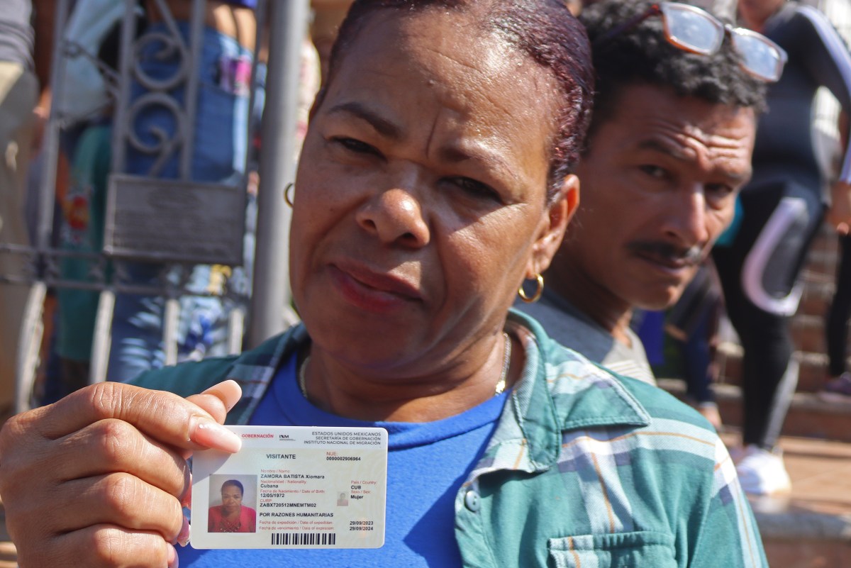 La inmigrante de origen cubano, Xiomara Zamora, muestra su documento como visitante otorgado por autoridades migratorias mexicanas.