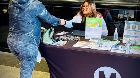 Xiclalilt Cabrera, del equipo móvil de LIFE, ayuda a una señora afuera de la estación 7th St/Metro Center.