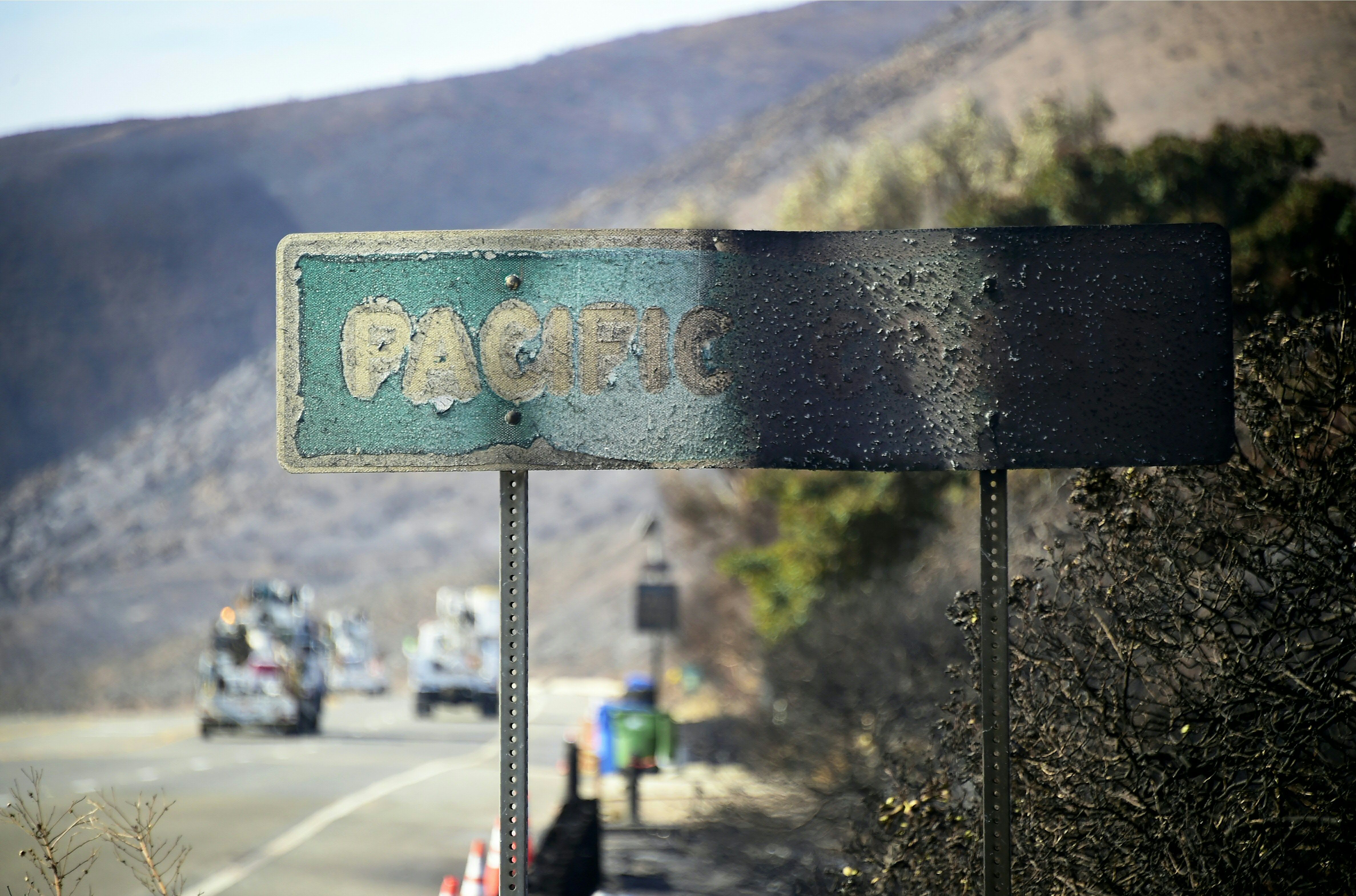 A fire-damaged Pacific Coast sign remains standing along the Pacific Coast Highway amid the blackened and charred hills from the Woolsey Fire in Malibu, California on November 15, 2018. - Much of the area remain under evacuation one week after the Woolsey Fire started. (Photo by Frederic J. BROWN / AFP) (Photo credit should read FREDERIC J. BROWN/AFP via Getty Images)