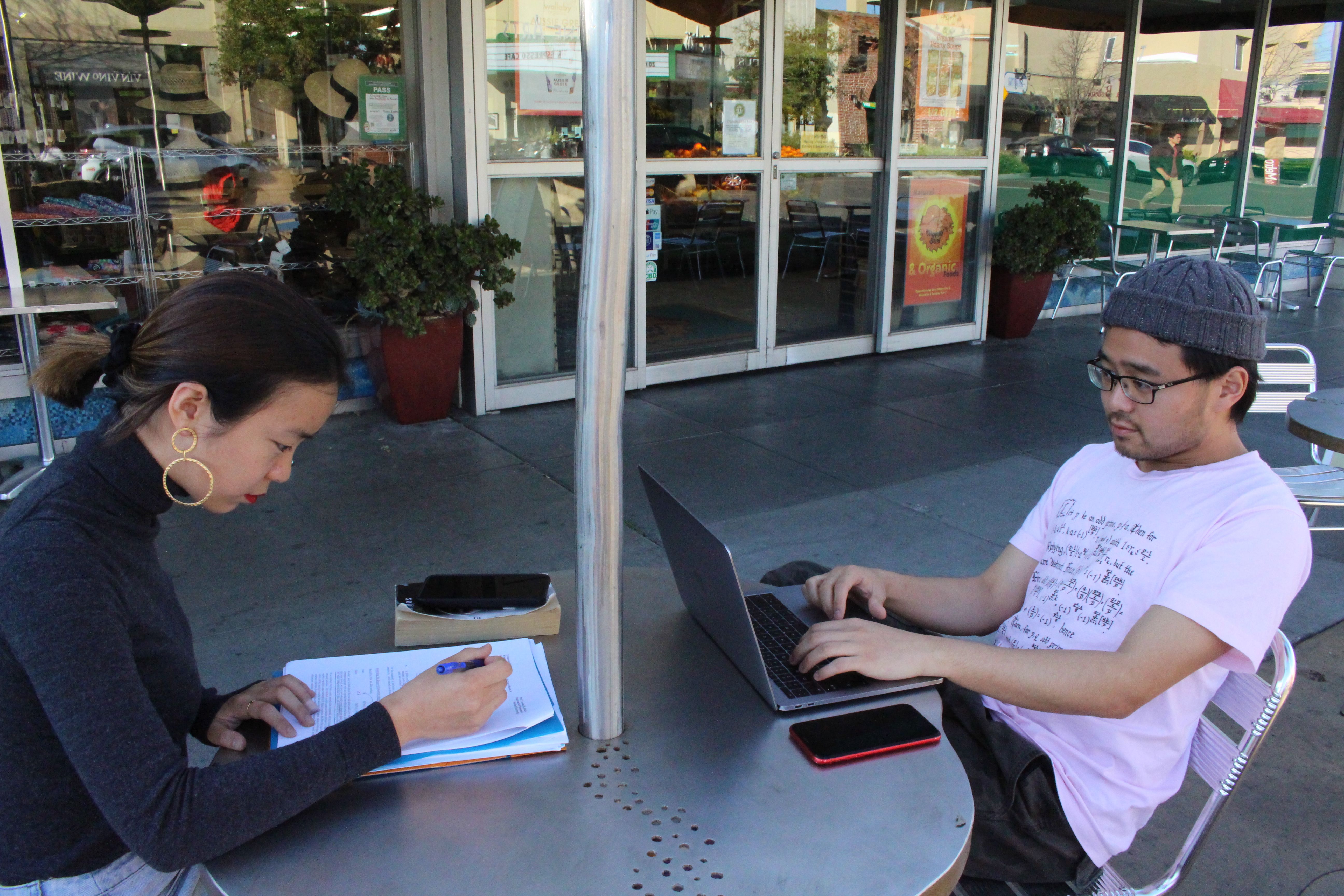 International students Yaqing "Victoria" Yang and Ende Shen of China study together at a sidewalk table in the Silicon Valley city of Palo Alto on March 12, 2020 to break from the on-campus isolation at nearby Stanford University where classroom lectures have been replaced with virtual sessions due to the risk of novel coronavirus. - Tech-savvy Silicon Valley is joining the trend of remote work and classes as people seek to contain the fast-growing disease, relying on many of the technologies invented or refined in the area. (Photo by Glenn CHAPMAN / AFP) (Photo by GLENN CHAPMAN/AFP via Getty Images)
