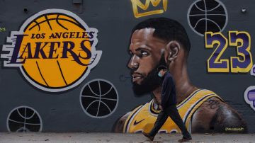 A man walks past street art by Joel Arroyo depicting US basketball player Lebron James in central Barcelona on November 12, 2020. - Spain's death toll surged over 40,000 with infections passing the 1.4 million mark, making it the country with the fourth-highest death rate within the EU. (Photo by Josep LAGO / AFP) / RESTRICTED TO EDITORIAL USE - MANDATORY MENTION OF THE ARTIST UPON PUBLICATION - TO ILLUSTRATE THE EVENT AS SPECIFIED IN THE CAPTION (Photo by JOSEP LAGO/AFP via Getty Images)