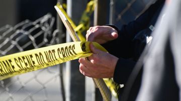 A San Mateo County Sheriff officer puts up police tape at a crime scene after a shooting at the Spanish Town shops in Half Moon Bay, California, on January 24, 2023. - A suspected gunman was in custody Monday over the killing of seven people in a rural community in northern California, just two days after a mass shooting at a Lunar New Year celebration near Los Angeles. (Photo by Samantha Laurey / AFP) (Photo by SAMANTHA LAUREY/AFP via Getty Images)