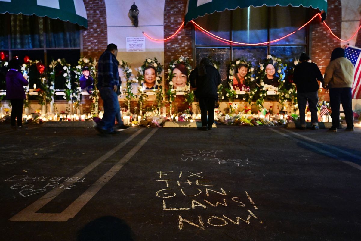 People pays their repect at a makeshift memorial for victims of a mass shooting in front of the Star Ballroom Dance Studio in Monterey Park, California on January 26, 2023. (Photo by Frederic J. BROWN / AFP) (Photo by FREDERIC J. BROWN/AFP via Getty Images)